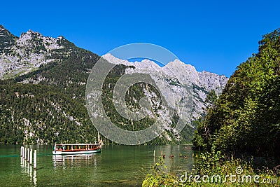 Lake Koenigssee with rocks and excursion boat in the Berchtesgaden Alps, Germany Stock Photo