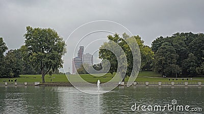 Lake with meadow, trees and skyscrapers in the park Editorial Stock Photo