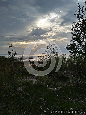 Sunset Lake Michigan north point pebbles waves water sky clouds vegetation beach evening view travel hike adventure scenic Stock Photo