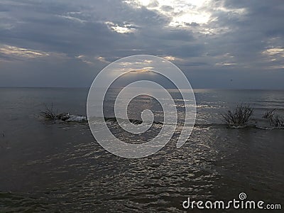 Lake Michigan north point pebbles waves water sky clouds vegetation beach evening view travel hike adventure scenic Stock Photo