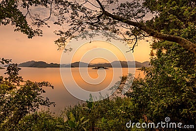 Lake Mutanda at sunset with view on the volcanoes mount Muhavuru and mount Gahinga in East Africa, along the border of Rwanda and Stock Photo