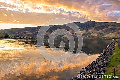 Lake with promenade, sunset sky reflection and foothills. Snake River on the border of Idaho and Washington states. Stock Photo