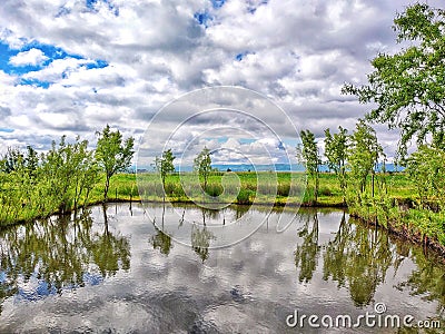 Lake reflections with clouds and trees Stock Photo
