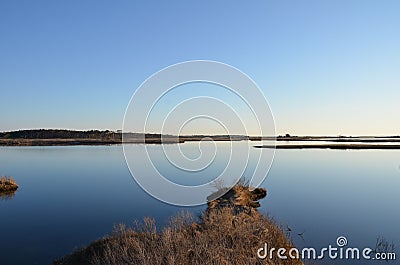 A lake or river with brown grasses and shore Stock Photo