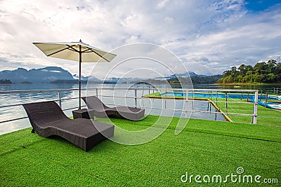 Lake view in summer with relaxation seat and umbrella in wooden terrace at Thailand Summer Season Stock Photo