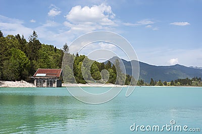 Lake Walchensee with boathouse and mountain range - Typical alpine lake in the bavarian Alps with incredible clear and turquoise Stock Photo