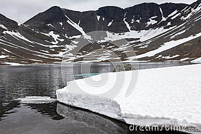 Lake with water from melted snow in highland of the Khibiny massif. The Kola Peninsula, Russia Stock Photo