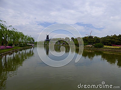 A lake with a windmill background at Shanghai flower port Stock Photo