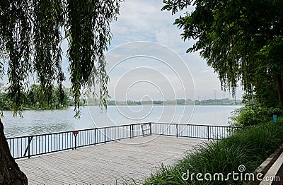 Lakeside fenced and planked platform in cloudy summer Stock Photo