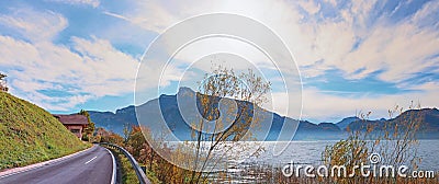 Lakeside road along lake Mondsee with mountain view and autumnal trees Stock Photo