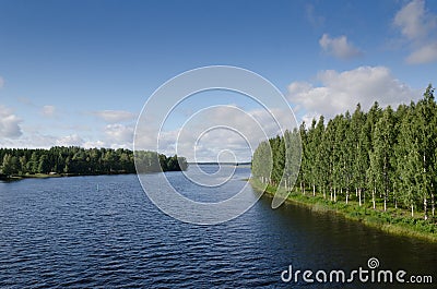 LakeVaskilampi Finland blue sky white clouds coniferous forest landscape Stock Photo