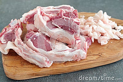 Lamb chopRaw lamb chops and fat on a olive wood cutting board on a grey abstract background. Healthy cooking concept. Stock Photo