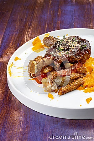 Lamb shank with demiglas sauce, carrot puree with caramelized vegetables Stock Photo