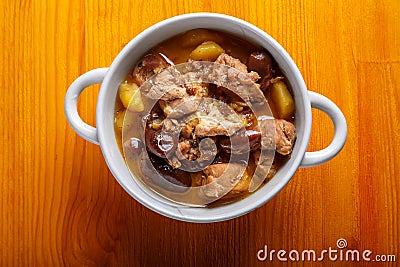 Lamb stewed with potatoes in spices and sauce in a soup bowl on the table Stock Photo