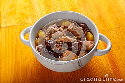 Lamb stewed with potatoes in spices and sauce in a soup bowl on the table Stock Photo