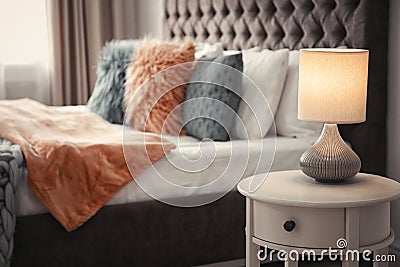 Lamp on bedside table in room Stock Photo