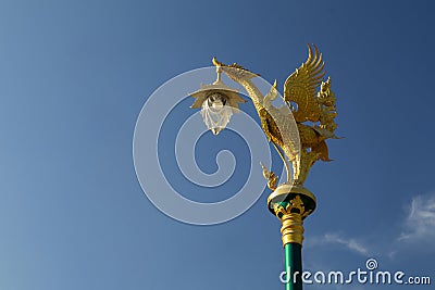 A Lamp hangs on A golden mythical Hongsa figure topped on a pole Stock Photo