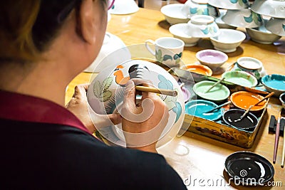 LAMPANG, THAILAND - JANUARY 7, 2018:worker paints chicken pattern on white clay ceramic plate Editorial Stock Photo