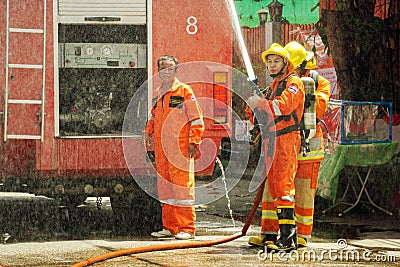 Firefighters group of Lampang city confederate water spray and control the hoses to quench Editorial Stock Photo