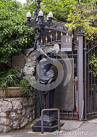 Lampost with female sculpture left side of Entrance gate to the five star hotel, Chateau de la Chevre Dor in Eze, France Editorial Stock Photo