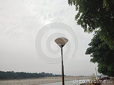 a lamppost by the sidewalk along the coastline in Chenab river Akhnoor Stock Photo