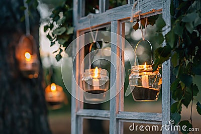 Lamps with candles are hanging on a tree at night. Wedding n Stock Photo