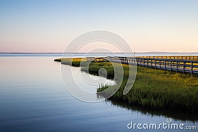 Land juts out onto water with a wood walkway Stock Photo