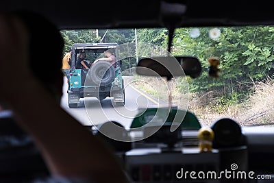 Land Rover Defender captured from other car. Off-road tour. Editorial Stock Photo