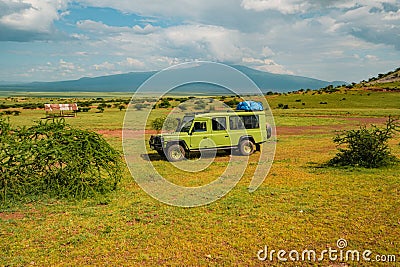 A Land Rover safari vehicle against a Mountain background at Ngorongoro Conservation Area in Tanzania Editorial Stock Photo