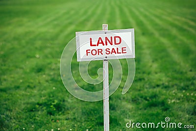 Land for sale sign against trimmed lawn background Stock Photo