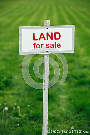 Land for sale sign against trimmed lawn background Stock Photo