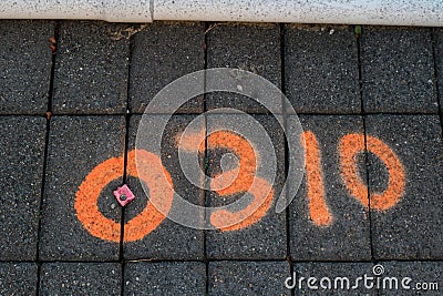 Land surveyors mark on tile paved sidewalk Stock Photo