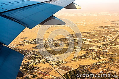 Land under the wing of an airplane from a height of flight. Desert, village, woods, fields. Amazing view from the window of the Stock Photo