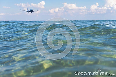 Landing airplane above transparent sea water Stock Photo