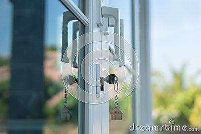 Landlord key for unlocking house is plugged into the door. Second hand house for rent and sale. keychain is blowing in the wind. Stock Photo