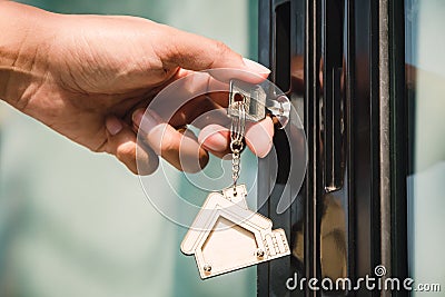 Landlord unlocks the house key for new house Stock Photo