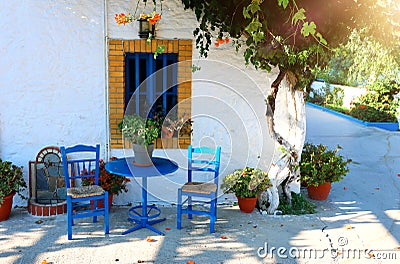 Landmark photo of blue chairs with table in typical Greek town Stock Photo