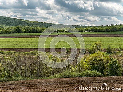 Landscape with Agriculture Fields and Green Areas on a Sunny Day with Cloudy Sky Stock Photo