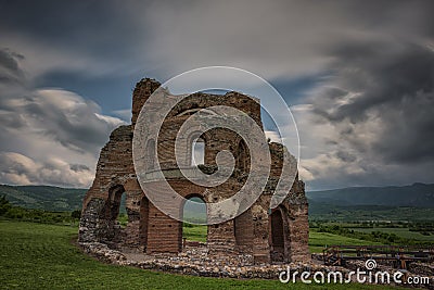 Landscape with antic church and dynamic clouds Stock Photo