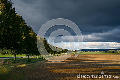 landscape in autumn, dark clouds and golden sun over agrultural fields near Göttingen, Germany Stock Photo