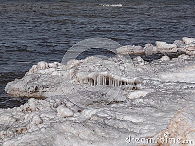 Landscape of Baltic sea and beach with ice and snow formations on the shore in bright sunlight. Frozen ice blocks and sea water in Stock Photo