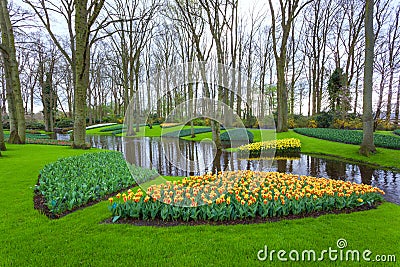 Landscape with blooming beautiful flowers and water stream in Keukenhof Stock Photo