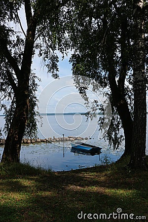 Landscape with blue fishing boat on the lake Seliger, Ostashkov, Russia Stock Photo