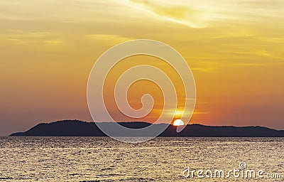 Landscape of colorful sunset shining over bright orange waters of the ocean. Silhouette paradise island of beautiful tropical Stock Photo