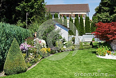 Landscape design of garden with grass and flowers Stock Photo