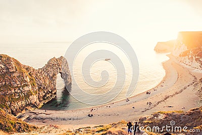 Landscape of Durdle Door with all over the world intarnational turists joining view of Sunset. Dorset, England. Selective focus. C Editorial Stock Photo