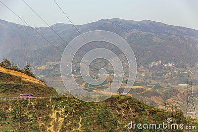 Landscape with electric posts and trees with pink color bus on the left side in summer in Sa Pa, Vietnam Stock Photo