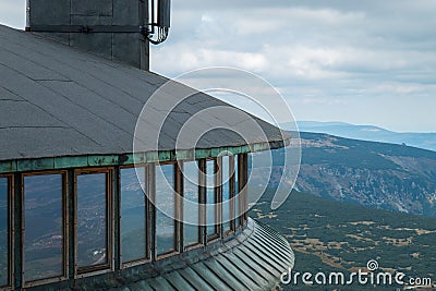 A landscape featuring undulating mountain peaks and a lookout point with metal-framed windows Stock Photo