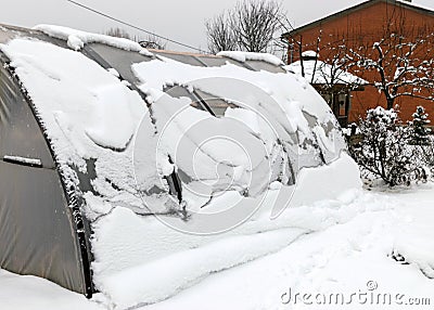 landscape with a film greenhouse, snow on the greenhouse, winter Stock Photo