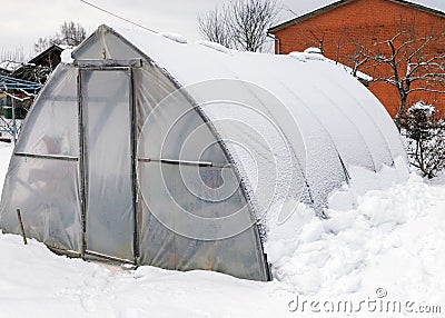 landscape with a film greenhouse, snow on the greenhouse, winter Stock Photo